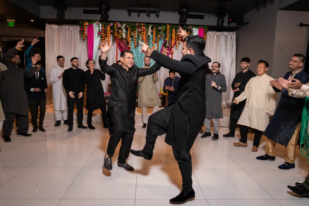 Group dancing at a festive cultural celebration with colorful decor