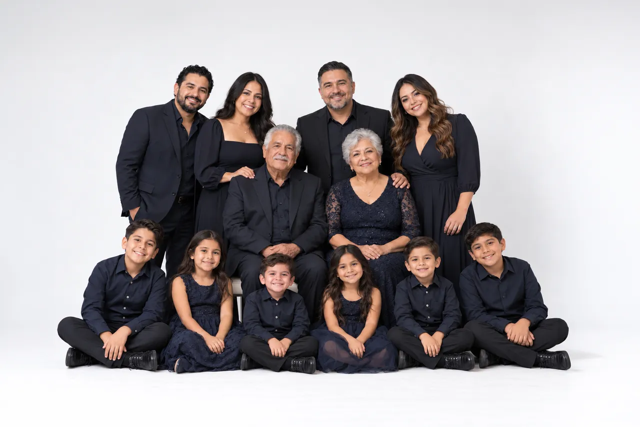Large extended family in coordinated black outfits posing together on a white studio backdrop, different arrangement