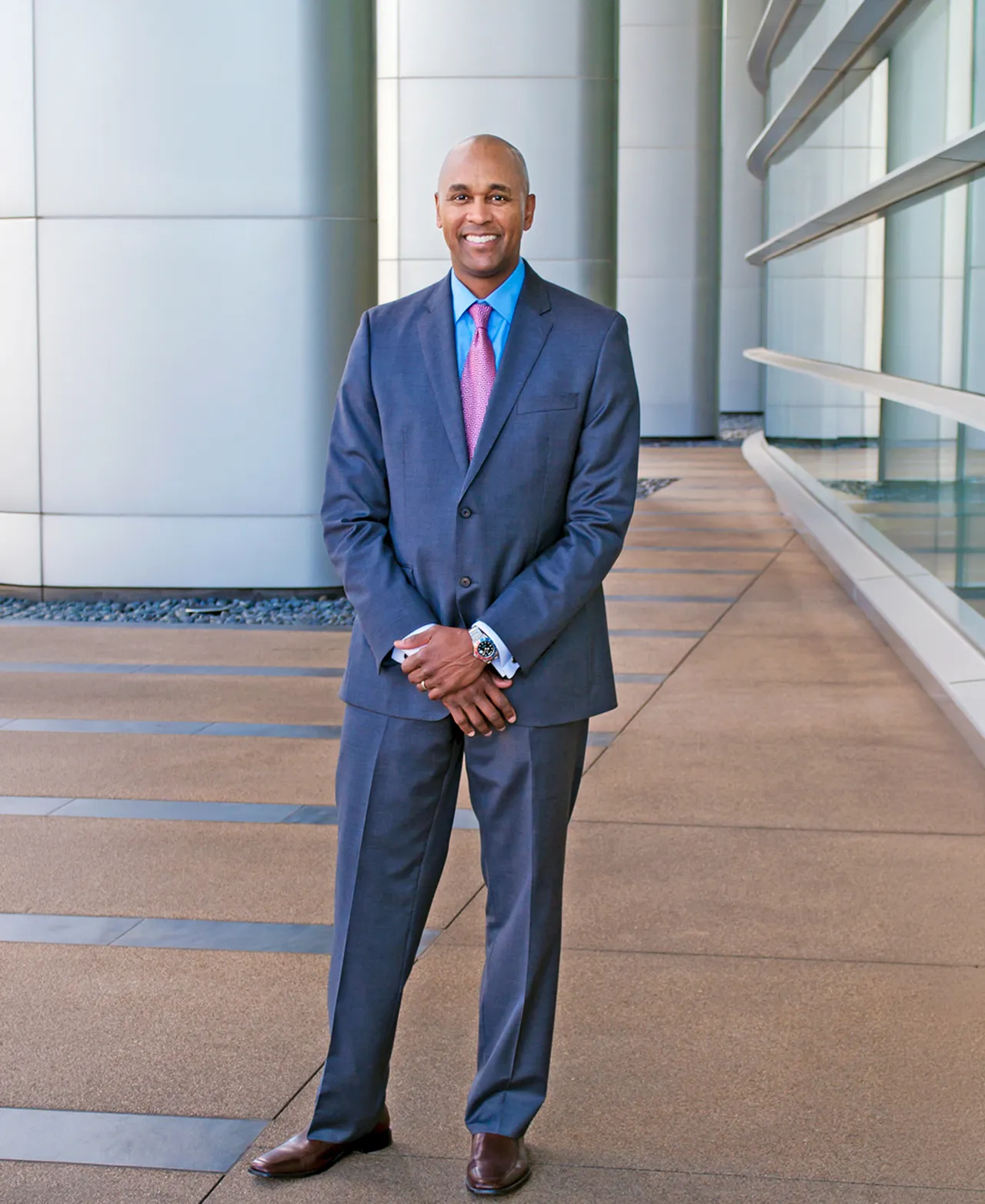 Editorial portrait of a man in a suit in a modern architectural setting