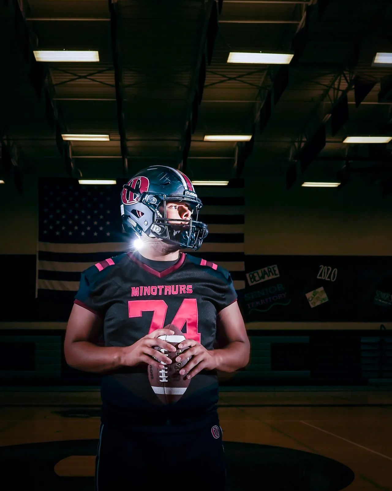 Football lineman in uniform holding the ball for an individual athlete portrait