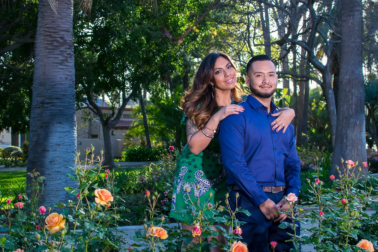 Couple embracing in a garden with roses and palm trees